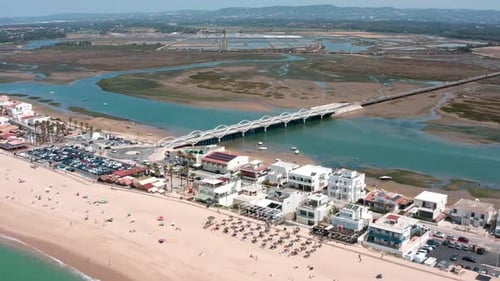 Aerial Panorama Revealing Faro Beach Historic Bridge and Ria Formosa Natural Park Showcasing