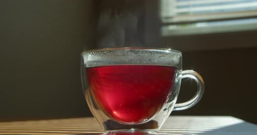 Teetasse mit natürlichem Teedampfrauch in der Küche in Zeitlupe