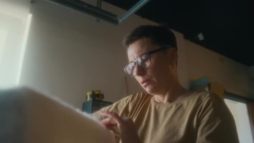 Woman Stapling Something Together in a Workshop
