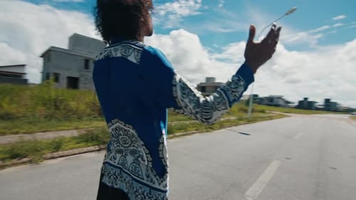 Homem estiloso afro-brasileiro fica na rua com as mãos estendidas