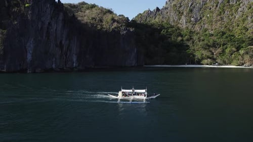 Asian Fishing Boat Sailing Along Tropical Island in Philippins on Background