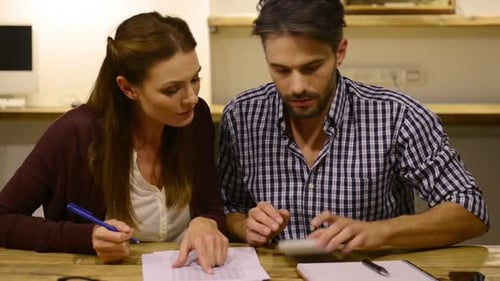 Couple review finances and paperwork together at home