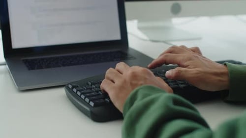 Mãos de um programador irreconhecível digitando no teclado