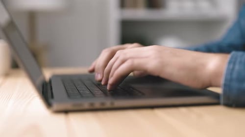 Close-up of Hands Typing on Laptop Keyboard