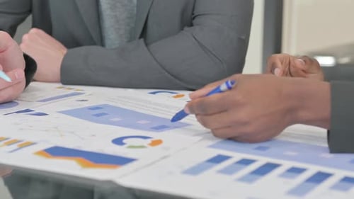 Close up of Hands Discussing Business Report at Work