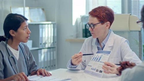 Medical Professionals Discussing Data in a Hospital Office