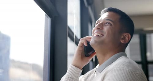 Business man, phone call and talking by window, chatting or speaking in office workplace