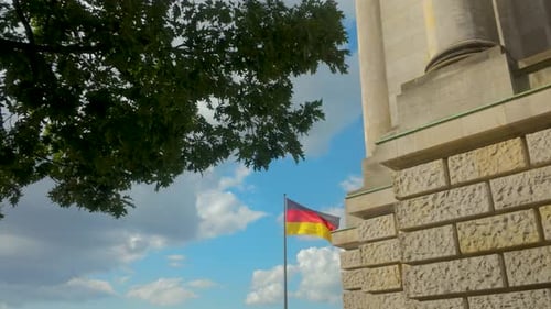 German Flag Waving Next to Stone Building
