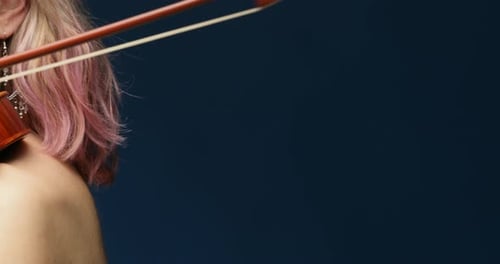 right to lef pan frontal view classic violinist playing violin with pink hair