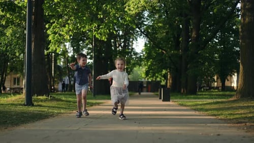 Wide Shot Excited Little Boy and Girl Running in Slow Motion on Alley Leaving Happy Carefree