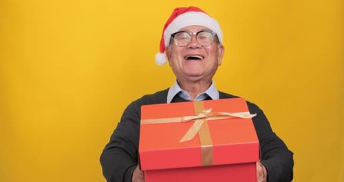 Senior Man Laughing Holding Christmas Gift