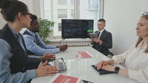 Diverse Colleagues in Office Meeting Discussing Data