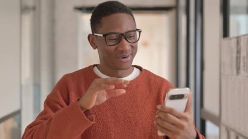 Young Adult Video Calling on Smartphone Indoors