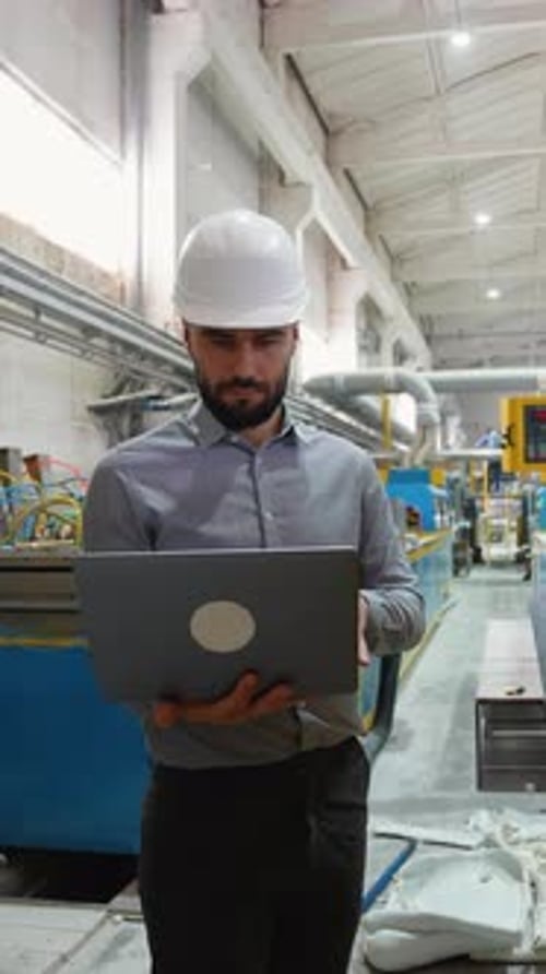 Industrial Engineer Using Laptop and Managing Production Line