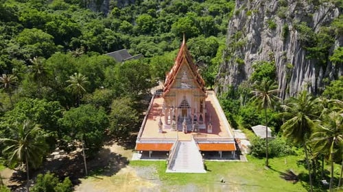 Aerial footage sliding to the right of this gorgeous temple seen from above surrounded by a forest a