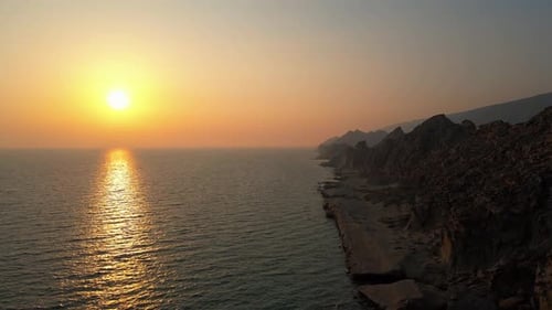 Breathtaking Sunset Over the Ocean with Rocky Shoreline in 4K