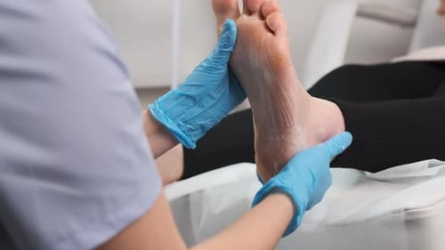 Health worker massaging patient's foot