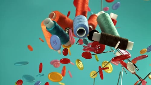 Colorful Thread Spools and Buttons Floating Against Blue Backdrop