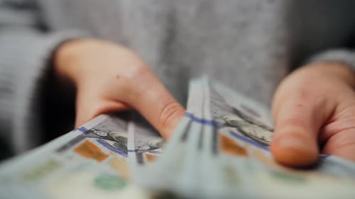 Hands Counting Stacks of United States Dollar Currency