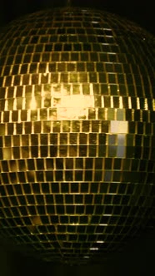 Dazzling disco ball spins in lively dance party. Vertical