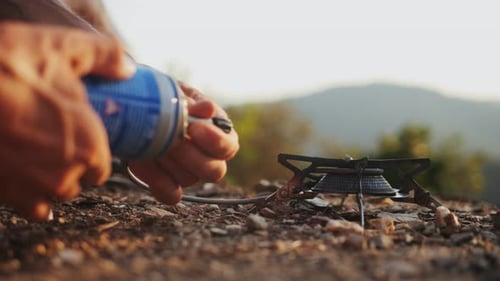 Hands Connecting Gas Canister to Portable Camping Stove