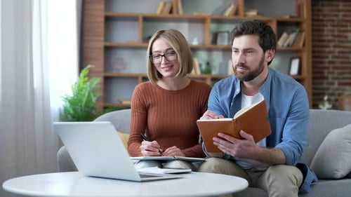Couple Works Together on Couch at Home