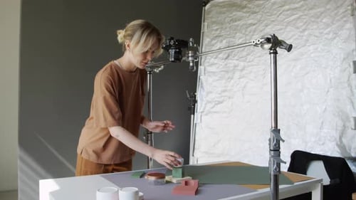 Woman Arranging Items for Camera Shoot in Studio