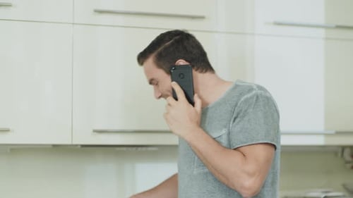 Man talking on phone in modern home kitchen