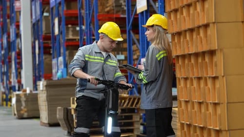 Warehouse supervisor walking and talking with dispatch worker