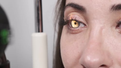 Attentive optometrist examining beautiful female patient with slit lamp in ophthalmology clinic. Opt