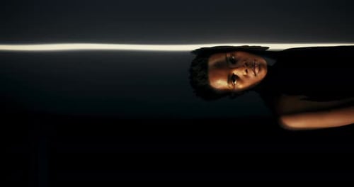 Person in Dark Room Lit by Single Light