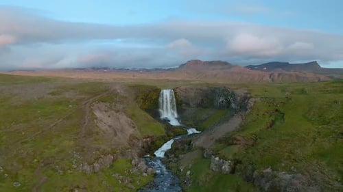 Approaching aerial of a waterfall in Iceland on a summer day.