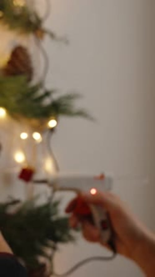 Person Gluing Christmas Decorations on Wall