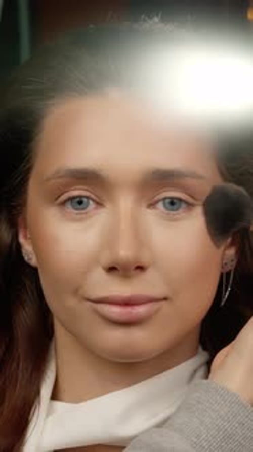 Makeup Professional Blending Foundation Seamlessly Using Soft Brush to Enhance Model's Skin Texture
