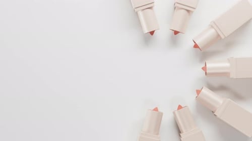 Top View on Peach Lipsticks Set Twists Up From Bege Tubes on Light Backdrop Lipstick Group Extend