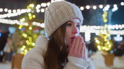 Cold Young Woman Warming Hands Outdoors at Night