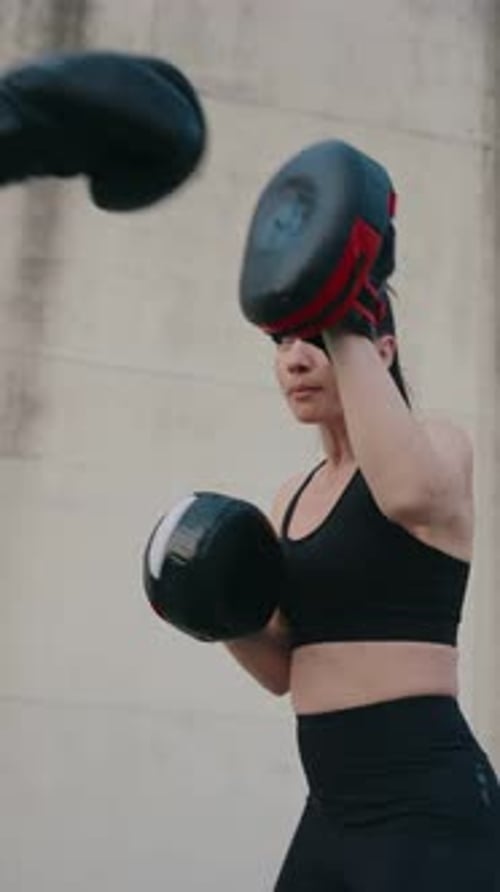 Woman Boxing with Trainer Outdoors