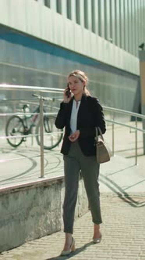 Professional Business Woman Walking Home While Talking on Phone in Urban Area
