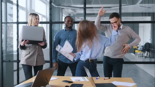 Happy, celebrating success. Professional workers are in the modern office together.