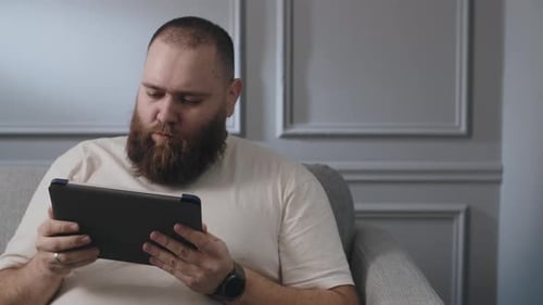 Man Using Tablet and Relaxing on Couch