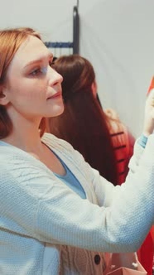 Woman Browsing Through Clothes in Store