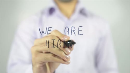 Man Writes "We Are Hiring" on Glass