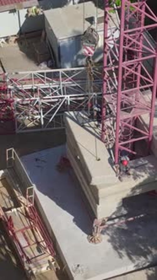 Vertical Video A Large Construction Crane Being Assembled By Engineers OnSite Captured From Above In