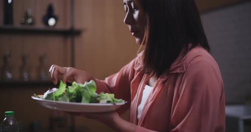 Young Woman Eats a Fresh Salad Indoors