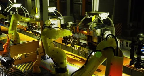 Robots industriels travaillant de nuit sur une chaîne de montage dans une usine de fabrication