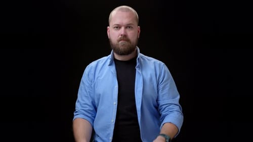 General View Bald Bearded Man in Blue Shirt Look in Camera and Shows Piece of Paper with the
