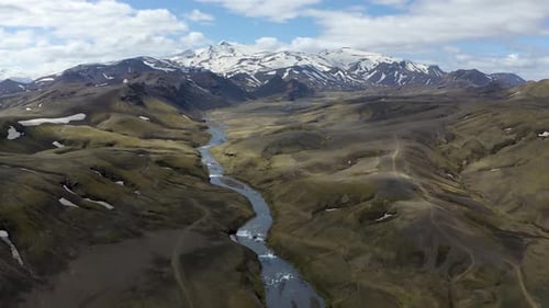 Flying a drone towards a mountain range capped with a glacier in the Highlands of Iceland. Slow moti