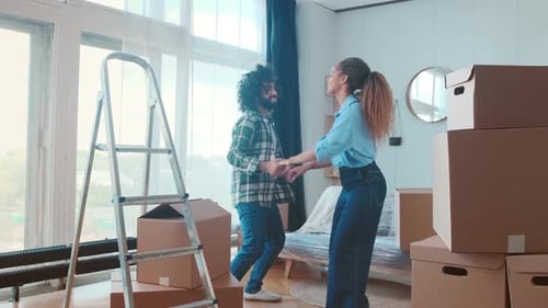 Happy Couple Dancing in New Home After Moving