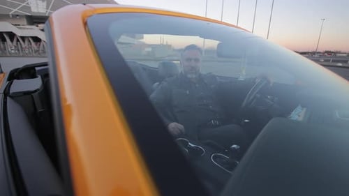 Joyful Man Singing in Yellow Convertible Bearded Man Singing Joyfully While Sitting in a Vibrant