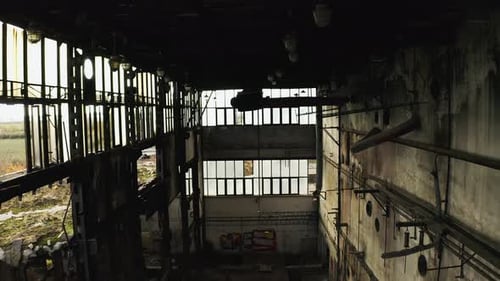 Amplio y revelador plano de una vieja fábrica industrial abandonada que se derrumba, tomada desde el techo